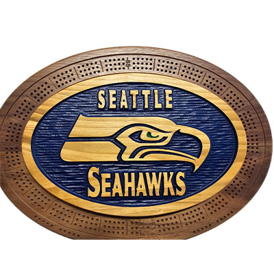 Oval wooden cribbage board with the Seattle Seahawks logo and name carved in the center, surrounded by score holes.